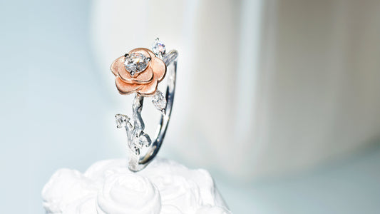 Custom white gold wedding ring with floral details and a rose-gold rose holding a solitaire diamond.