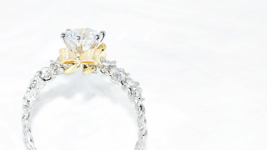 Custom engagement ring with six-prong diamond, floral setting, and yellow ribbon-inspired prong design