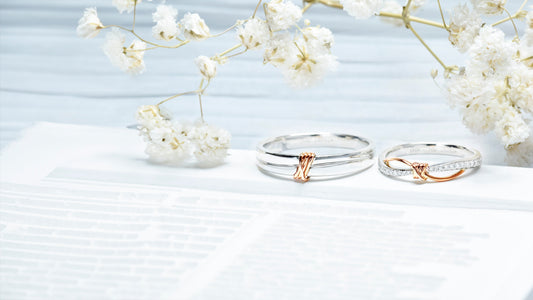 Customized White gold wedding band featuring central rose gold knot; female band includes infinity-shaped curve integrated with pave diamonds