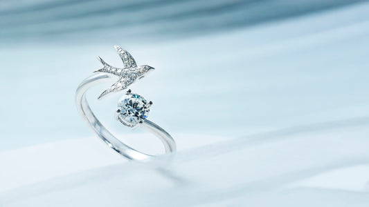Custom white gold engagement ring with split band, swallow-shaped design on one side, and solitaire diamond on the other.