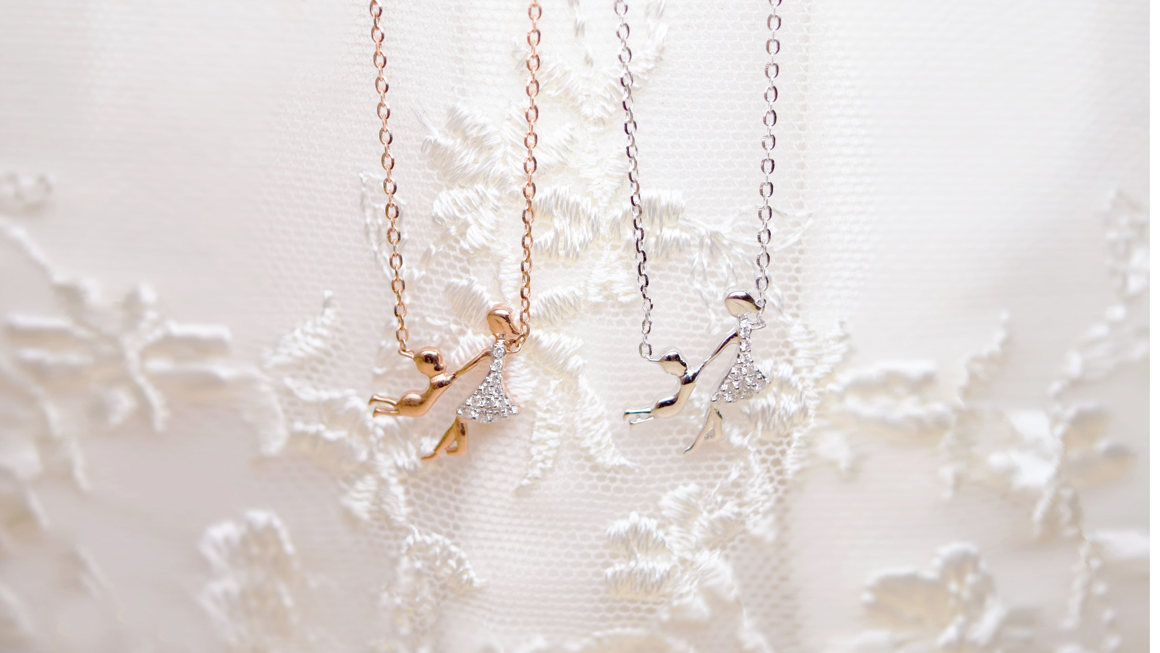 Two custom design necklaces in rose gold and white gold on a light background